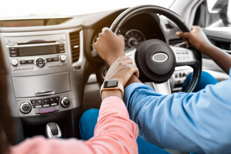 Black couple enjoying drive on car, holding hands