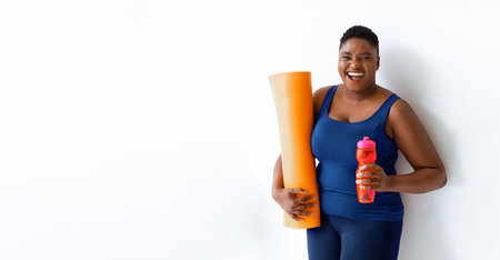 Woman Holding Yoga Mat and Water Bottle in Bright Room Before Exercise Session