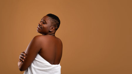 Beautiful plus size African american woman embracing herselfの写真素材