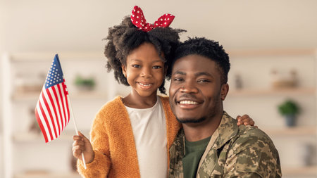 Smiling Man Holds Daughter With American Flag in Indoor Setting During Celebrationの写真素材