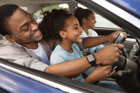 Cheerful African American Dad Teaching Preteen Daughter To Drive Carの写真素材