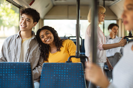 Happy smiling guy and lady taking bus togetherの写真素材