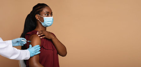 Side view of black woman getting vaccination