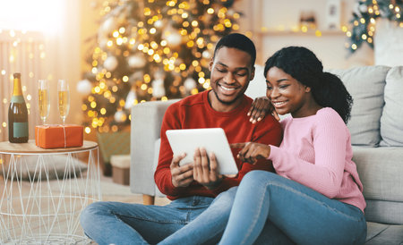 Couple Enjoying Time Together While Using a Tablet During the Holiday Season Celebrationの写真素材