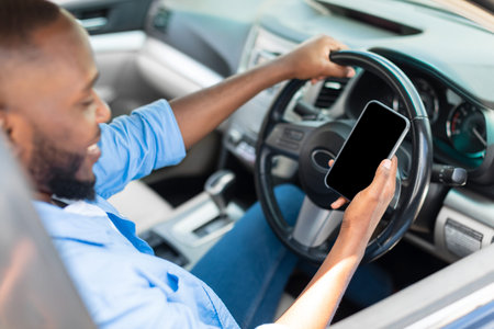 Happy black man using showing smartphone with empty screen