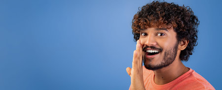Man Shouts Joyfully While Smiling and Looking to the Side With a Blue Background