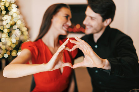 Happy smiling couple making heart shape with handsの写真素材