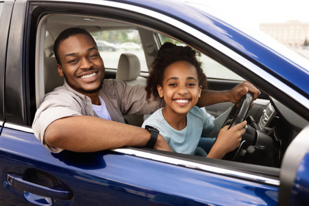 Black Daddy Teaching Preteen Daughter To Drive Smiling To Camera