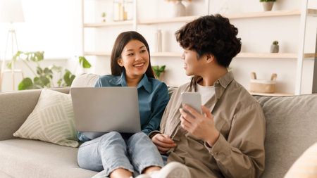 Friends Enjoy Time Together at Home While Working and Sharing Ideas on a Couchの写真素材