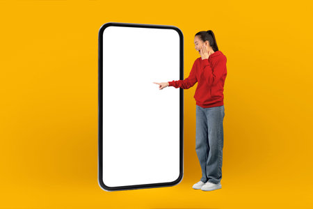 Person Standing Next to a Large Empty Screen on a Bright Yellow Background in a Studio Setting