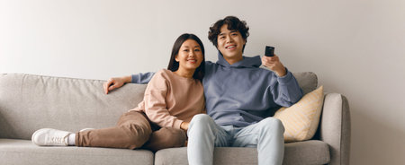 Couple Enjoys Time Together on Couch While Watching Television in Their Living Roomの写真素材