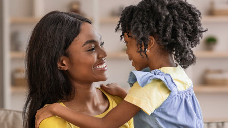 Joyful Interaction Between Mother and Daughter at Home in Cozy Living Room Settingの写真素材