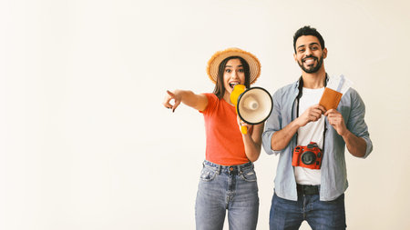 Happy couple with megaphone announcing, panorama with free spaceの写真素材