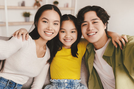 Smiling teenager korean girl, millennial woman and man make family selfie on gadget in minimalist...