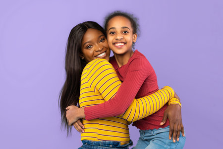 Family Members Smile and Hug Each Other Against a Purple Background During a Fun Moment