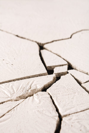 Cracked Surface Reveals Texture and Patterns in a Dry, Solid Material During Daylightの写真素材