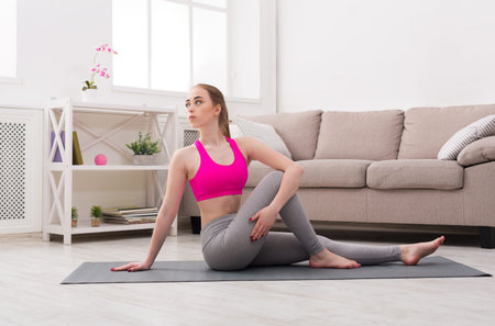 Woman Practicing Yoga in Living Room on Mat During Afternoon