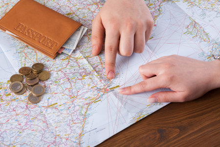 Planning a Trip With a Map, Money, and a Passport on a Wooden Table