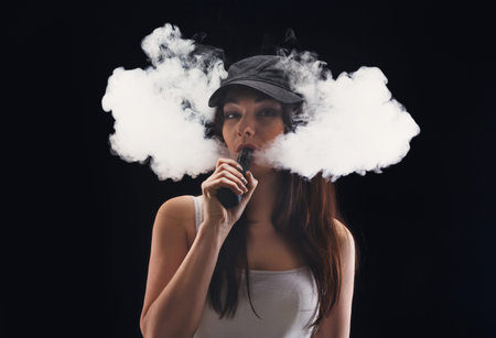 Woman Vapes Indoors Producing Large Clouds of Vapor While Wearing a Cap