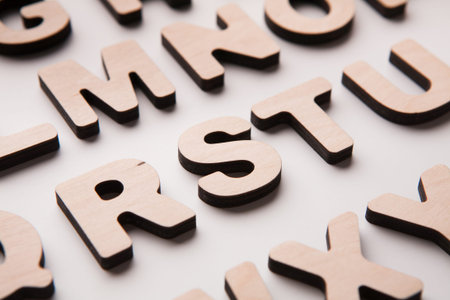 Wooden Letters Arranged on a Flat Surface With a Focus on Letter S and Surrounding Letters