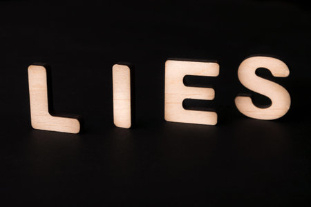 Wooden Letters Spelling Lies on a Dark Background in a Simple Art Display