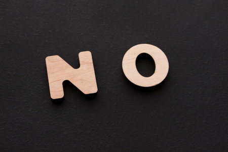 Wooden Letters Spelling No Displayed on Dark Background During Indoor Setting