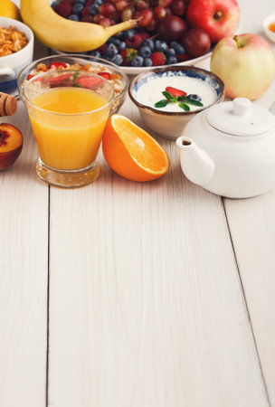 Collection of Fresh Fruits and Beverages Arranged on a Wooden Table for Morning Meal