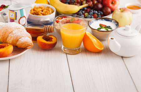 Breakfast Table Setup With Fruits, Drinks, and Baked Goods in a Cozy Setting