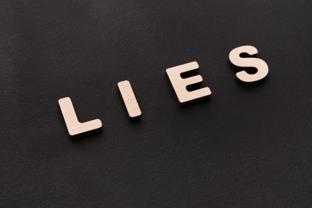 Letters Arranged to Spell Lies on a Dark Surface Showing Concepts of Truth and Deception