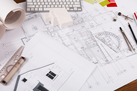 Collection of Architectural Blueprints and Drafting Tools on a Workspace for Building Design