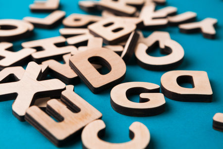 Wooden Letters Scattered on a Blue Background During a Creative Activity for Childrenの写真素材