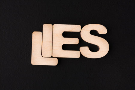 Wooden Letters Spell Lies on a Dark Background in a Simple Setup Exploring Themes of Truthの写真素材