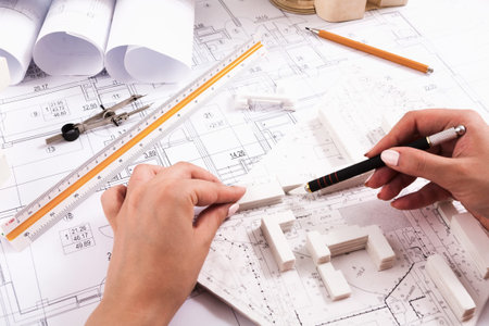 Designing a New Building With Plans and Models in an Architects Workspace