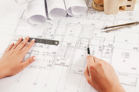 Drawing Plans and Designs on a Large Set of Blueprints and Sketches in an Office Space