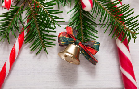 Collage of Christmas Decorations With Candy Canes and a Bell on a Wooden Background