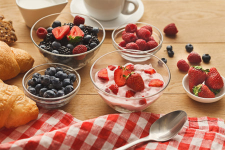 Collection of Fresh Fruits and Yogurt Served With Croissants on a Wooden Table