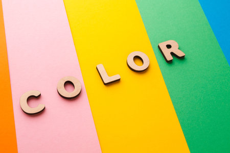 Bright Letters Spelling Color on Colorful Paper Stripes in Different Shades