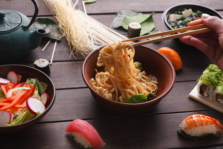 Collection of Asian Dishes Displayed on a Wooden Table With Chopsticks and Ingredients Present