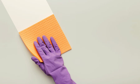 Cleaning Activity With a Purple Glove and Sponge on a Light Surfaceの写真素材