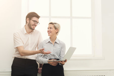 People Sharing Ideas and Working Together While Looking at a Laptop in a Bright Room