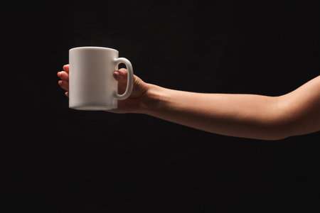 Hand Holds a White Mug Against a Dark Background in a Simple Collection of Visuals