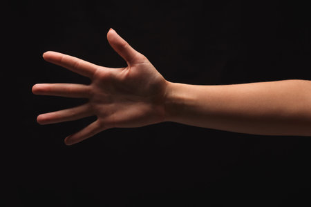 Hand Reaching out in a Dark Setting