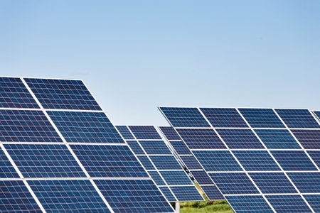 Solar Panels in a Green Field Under a Clear Blue Sky During Midday Hoursの写真素材