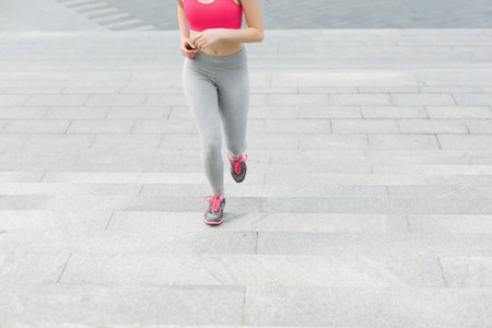 Woman Jogging up Stairs in Sportswear During the Day in a City Area