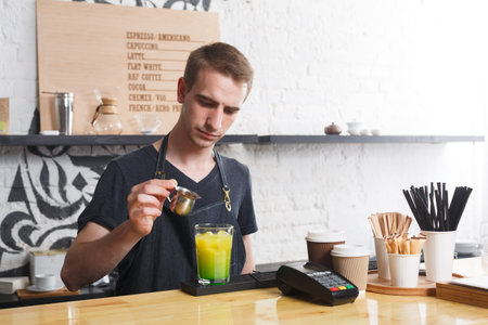 Barista Prepares a Colorful Drink at a Coffee Shop During the Afternoon Shift