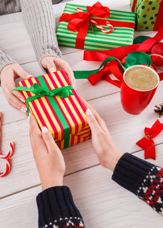 Gift Exchange During Holiday Season With Decorations and Warm Drinks