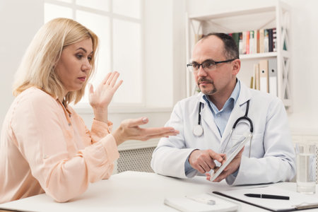 Doctor and Patient Discuss Health Concerns in a Medical Office Settingの写真素材