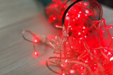Colorful Lights Spill From a Jar Creating a Bright Display on a Wooden Table