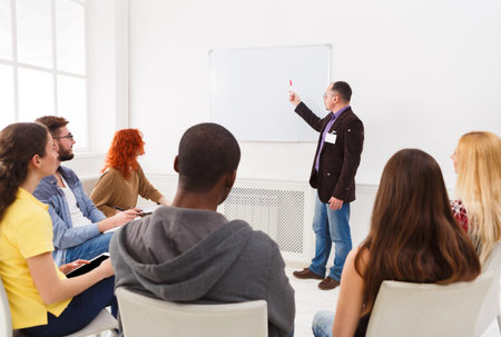 Group of People Attending a Training Session With a Presenter in a Bright Room