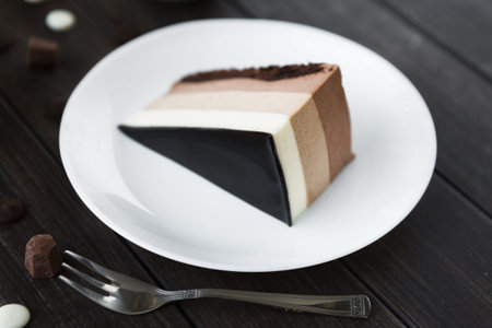Collection of Layers in a Slice of Cake on a White Plate With Silver Fork at a Dining Table